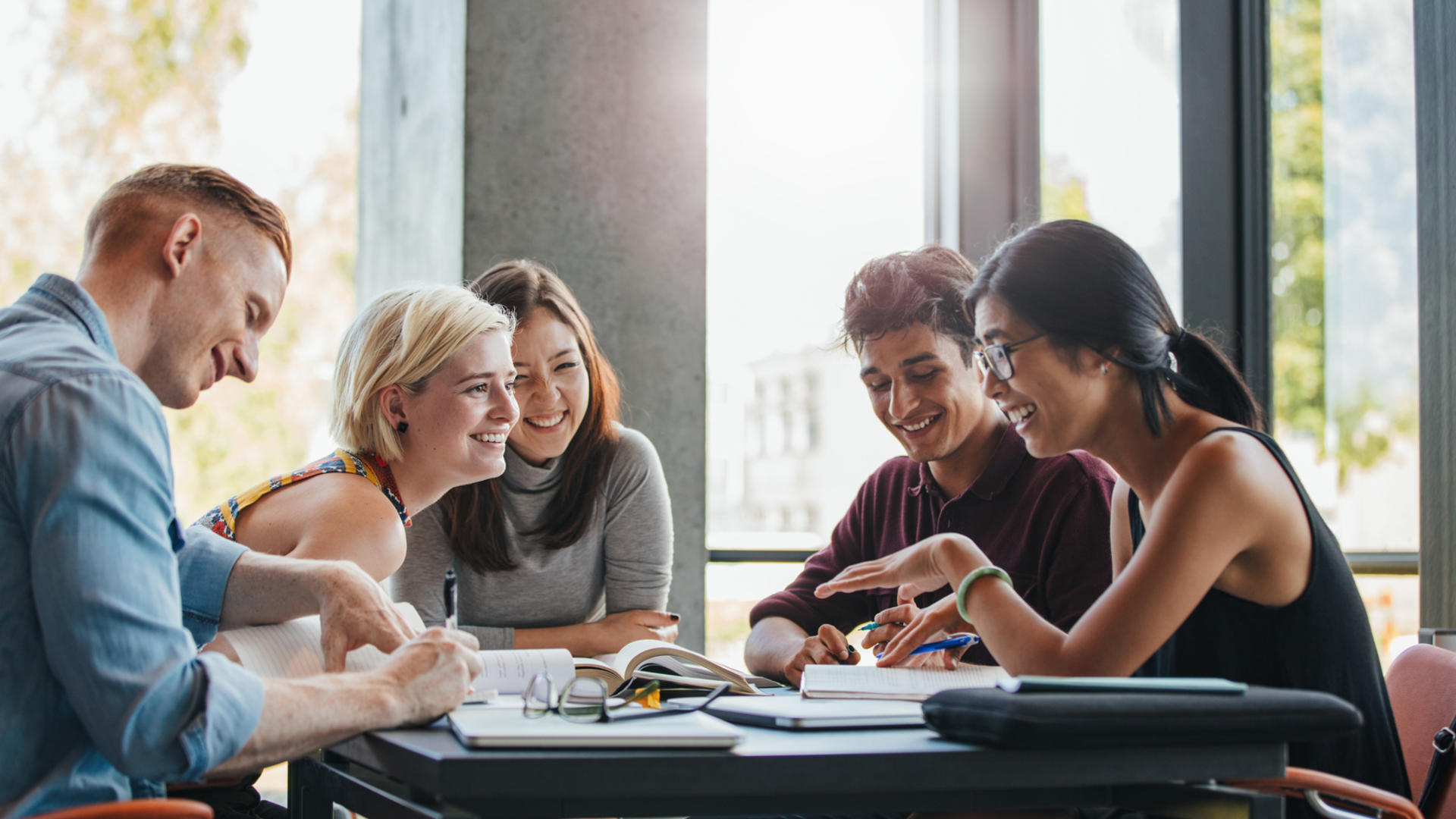 étudiants autour d'une table dans une bibliothèque groupe étudiants heureux bibliothèque